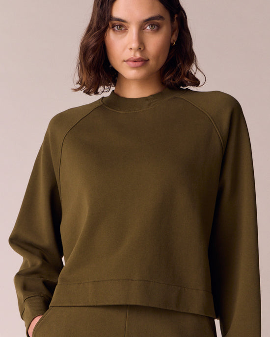 model wears earth green jersey jumper