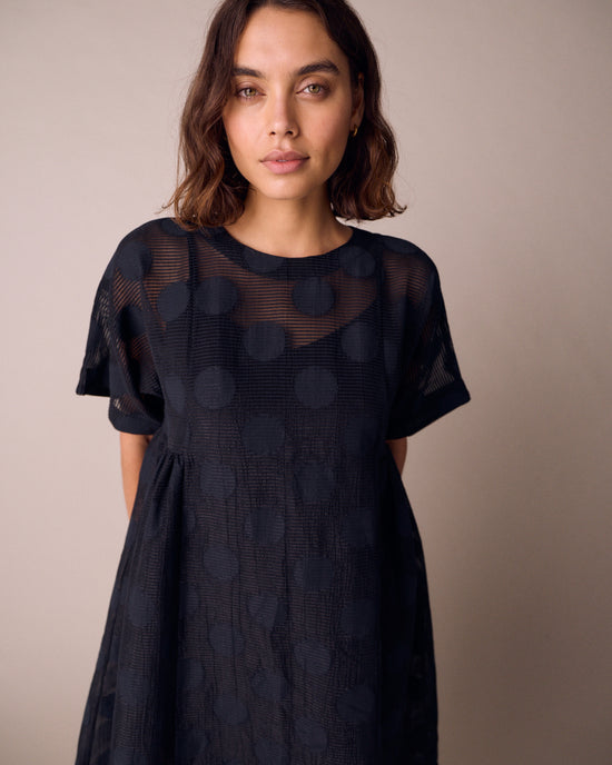 model wears zyla black sheer spot dress