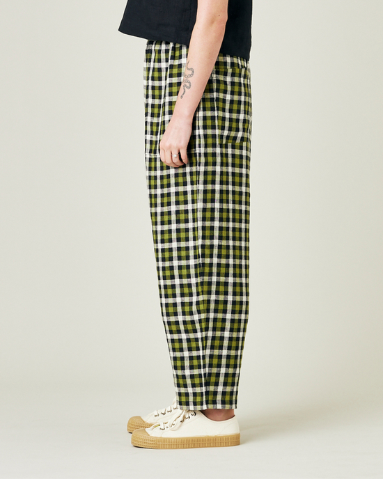 model wears olive black and ecru checked huxley trousers left