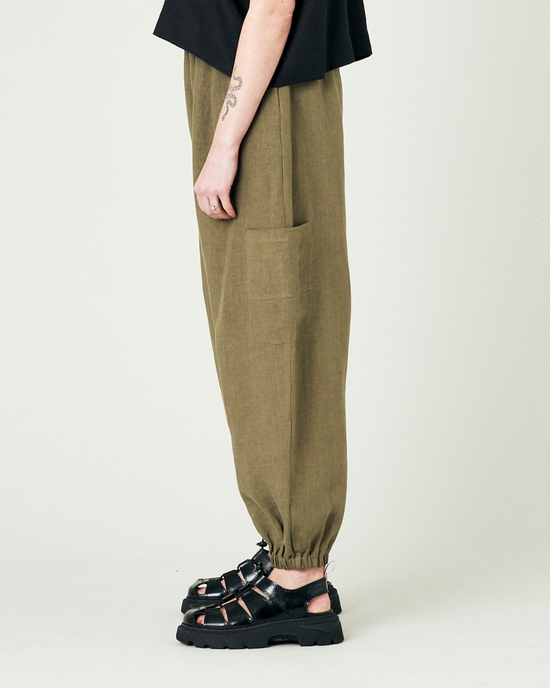 model wears light khaki linen yoli trousers left