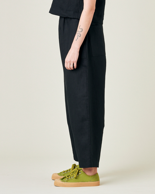 model wears black linen huxley trousers left