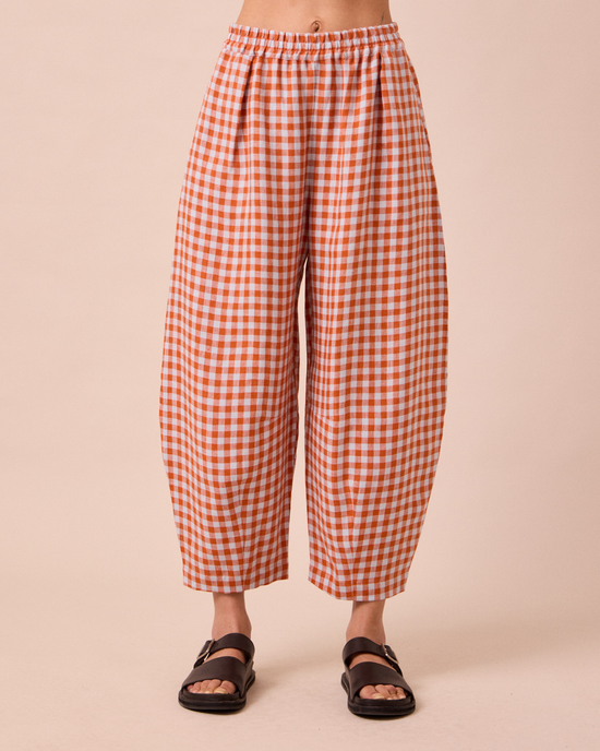 model wears daisy burnt orange gingham linen trousers front