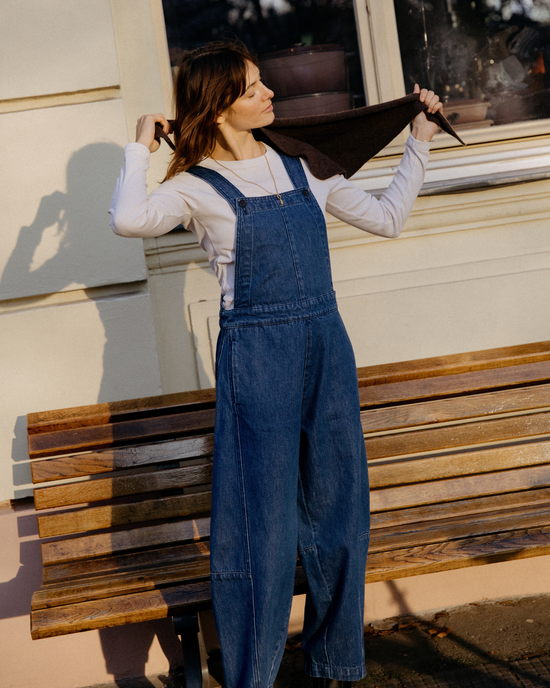 model wears gwynne mid blue denim dungerees