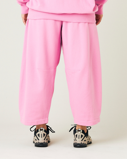 model wears pink daisy jersey trousers back