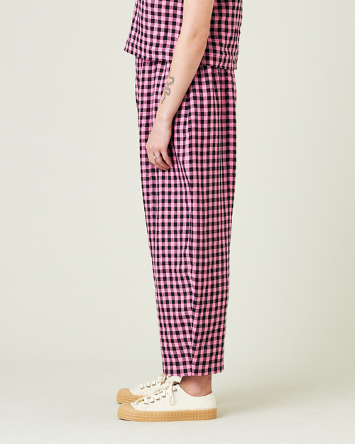 model wears pink and black gingham linen mabel trousers from the left