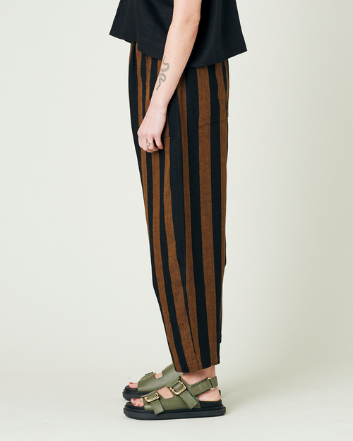 model wears rust stripe huxley trousers left