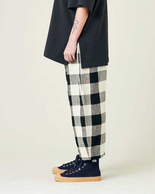 model wears stone and black mega check linen mabel trousers from the left