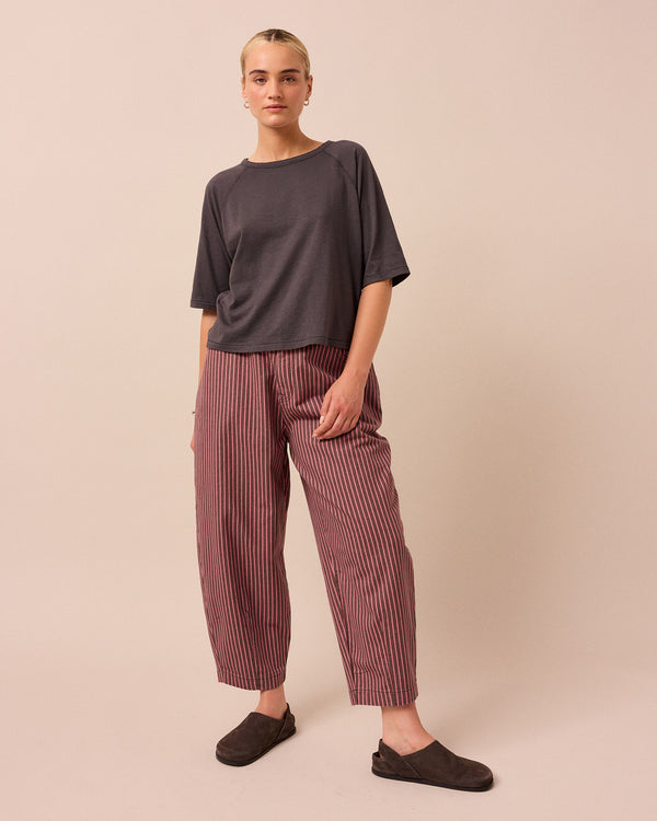 model wears remi pink and mocha stripe denim trousers right