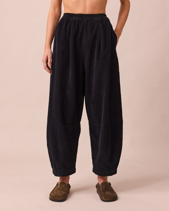 model wears daisy black cord trousers front