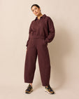 model wears lyra burgundy fleeceback jersey trousers left