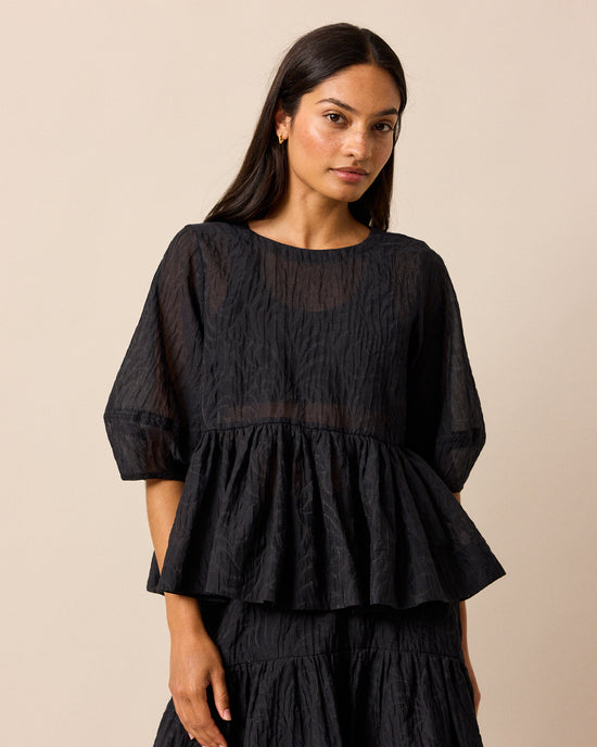 model wears priya black organza top