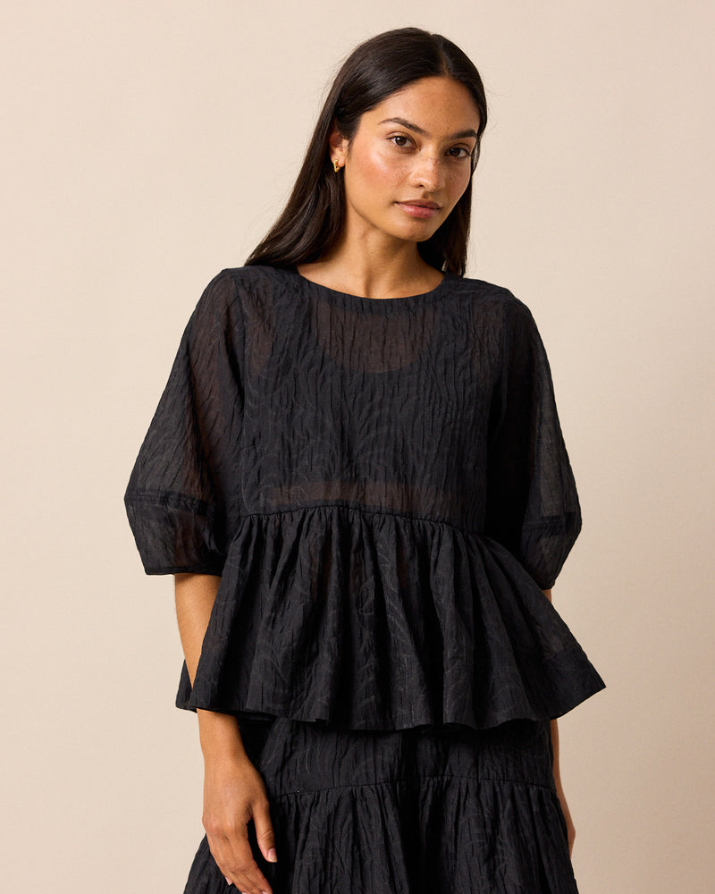 model wears priya black organza top