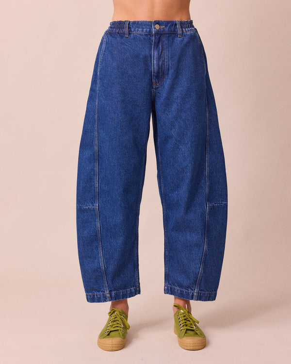 model wears tori mid blue wash denim jeans front