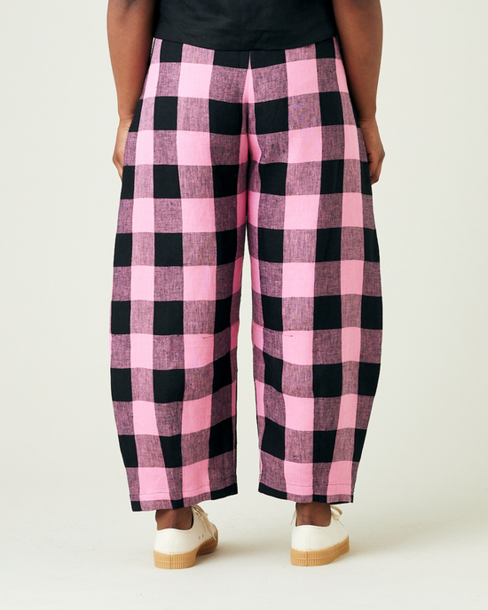 model wears daisy pink and black mega check linen trousers back