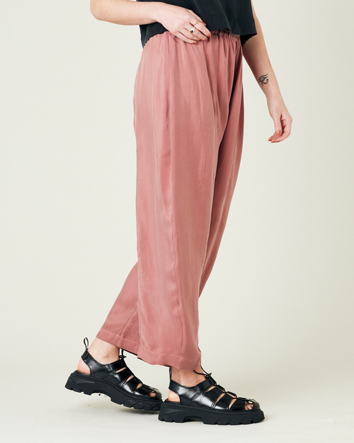 model wears dusty pink cupro trousers right