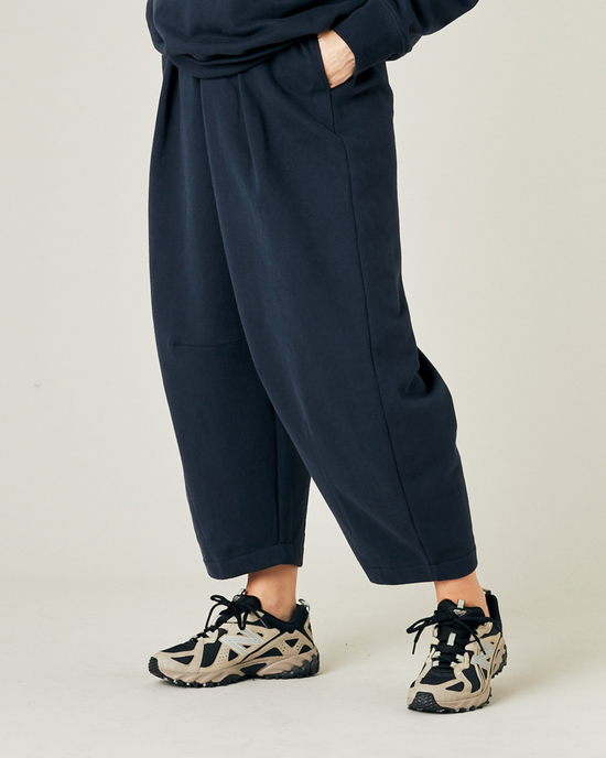 model wears navy daisy jersey trousers left