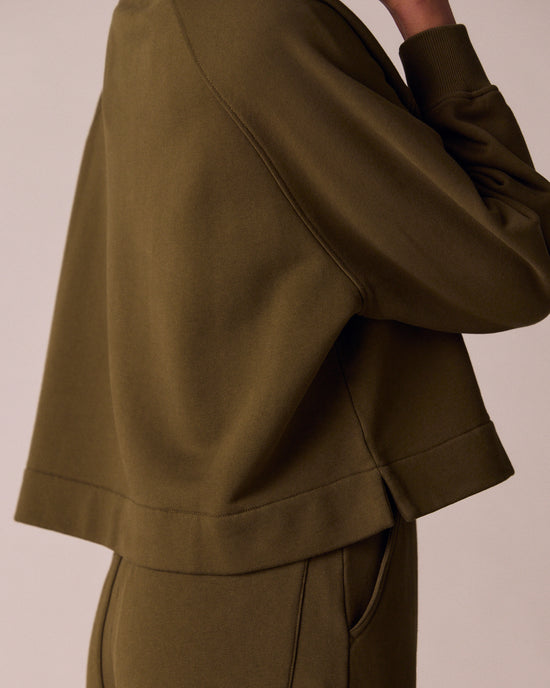model wears earth green jersey jumper
