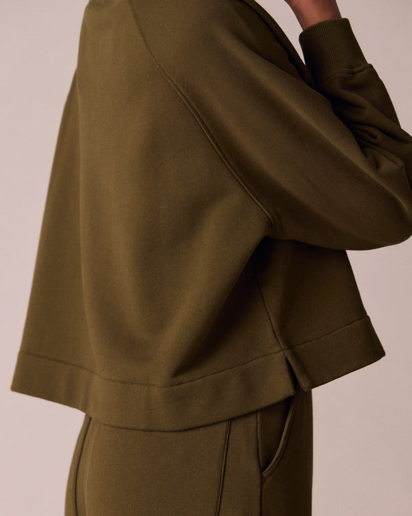 model wears earth green jersey jumper