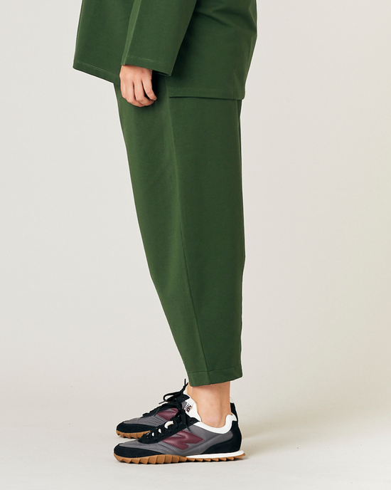 model wears kombu green jersey huxley trousers left