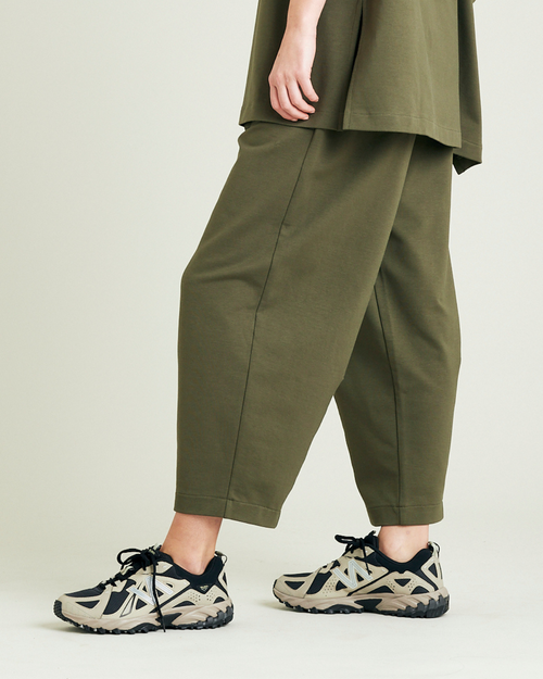 model wears olive huxley jersey trousers left