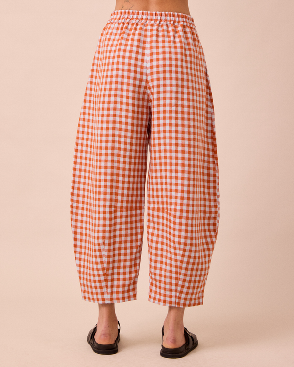 model wears daisy burnt orange gingham linen trousers back