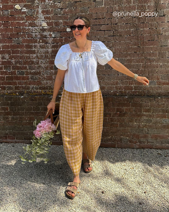 model wears mabel ochre gingham linen trousers