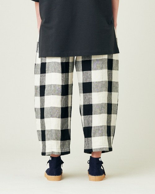 model wears stone and black mega check linen mabel trousers from the back