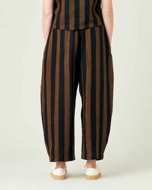 model wears rust stripe linen mabel trousers from the back