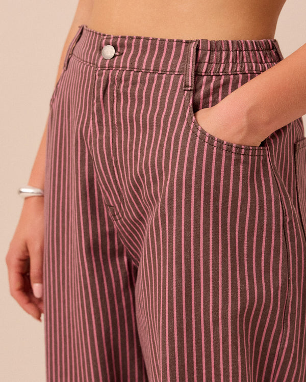 model wears remi pink and mocha stripe denim trousers