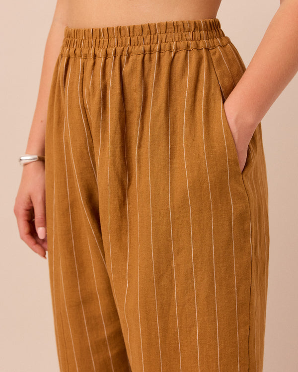 model wears honey pinstripe linen trousers