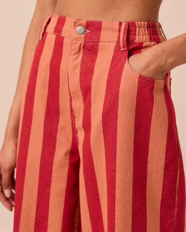 model wears peach and russet remi denim trousers right