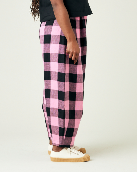 model wears daisy pink and black mega check linen trousers right