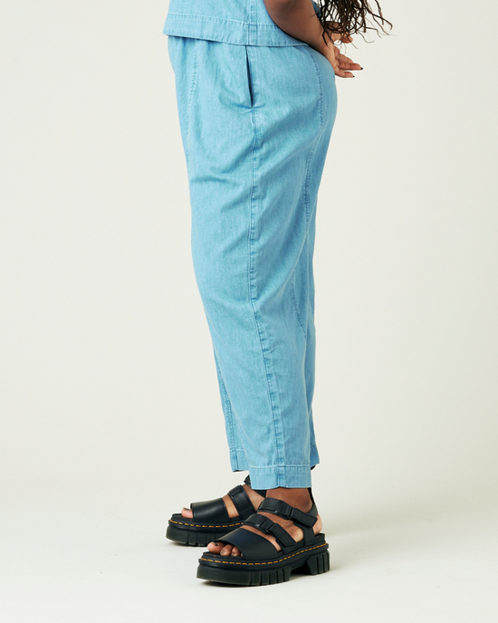 model wears light wash chambray mabel trousers left