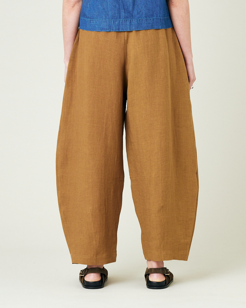 model wears bronze daisy linen trousers back