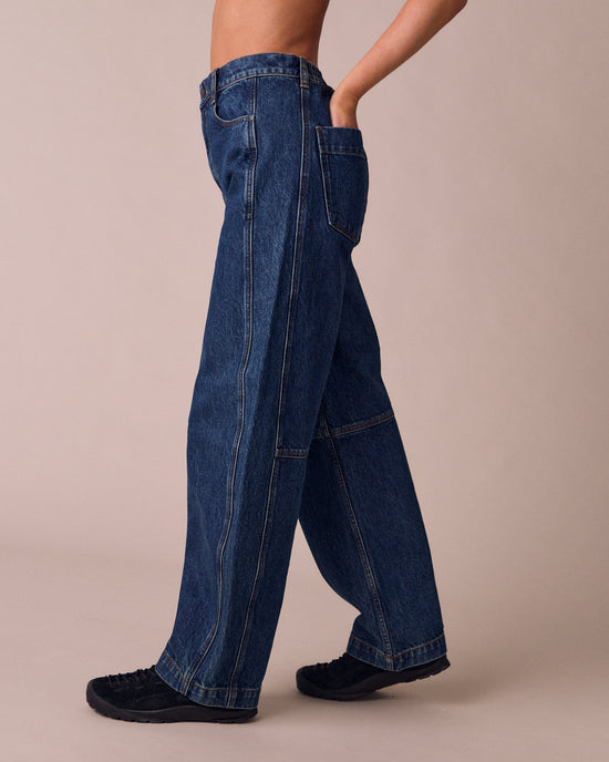 model wears echo mid wash denim jeans left