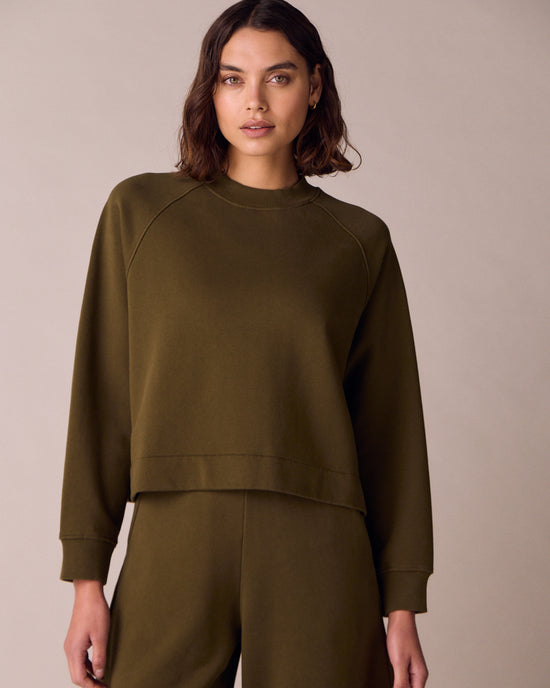 model wears earth green jersey jumper