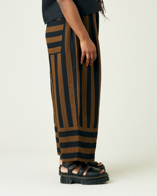 model wears rust stripe bobbi trousers right