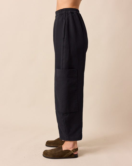 model wears amala black quilted cotton trousers left