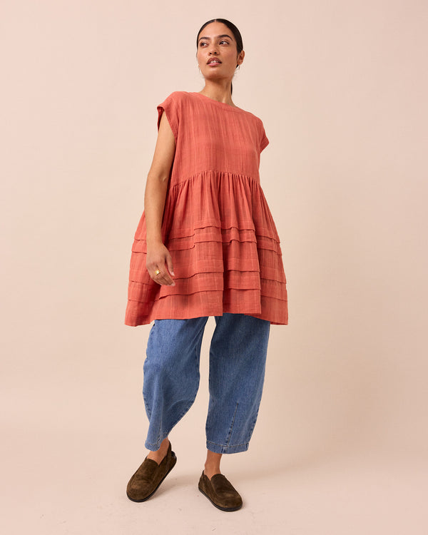 model wears ella terracotta cotton gauze dress