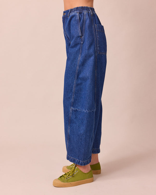 model wears tori mid blue wash denim jeans left