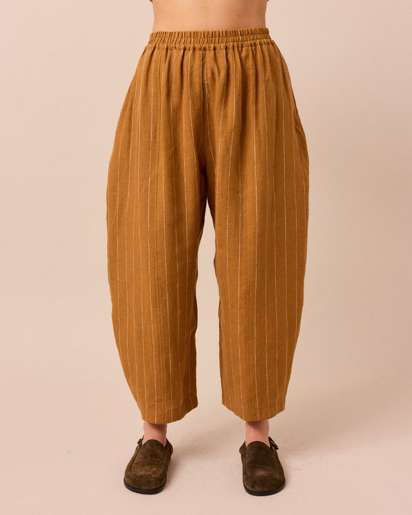 model wears honey pinstripe linen trousers front