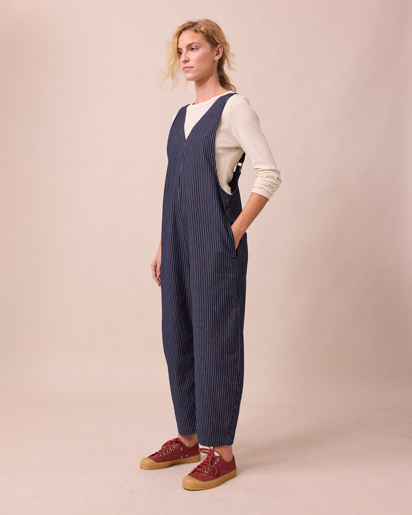 model wears ottie navy pinstripe denim jumpsuit