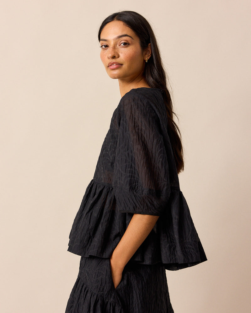 model wears priya black organza top