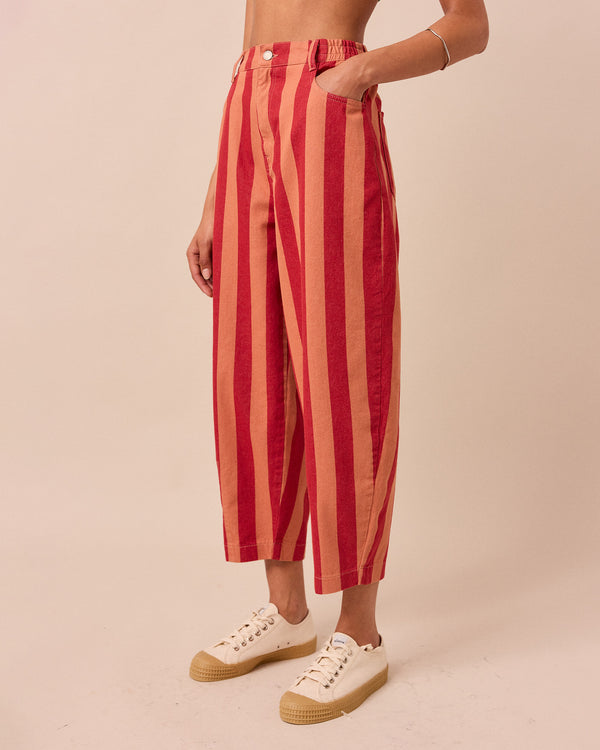 model wears peach and russet remi denim trousers left