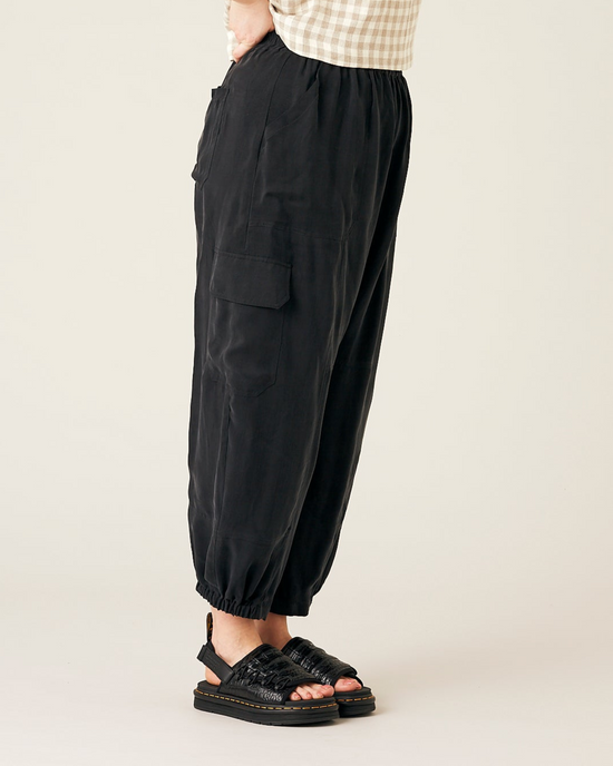 model wears black cupro sylvie trousers right