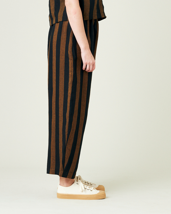 model wears rust stripe linen mabel trousers from the right