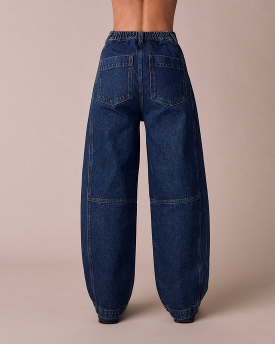 model wears echo mid wash denim jeans back