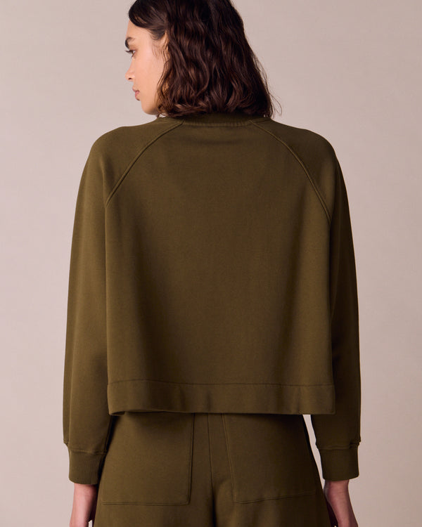 model wears earth green jersey jumper