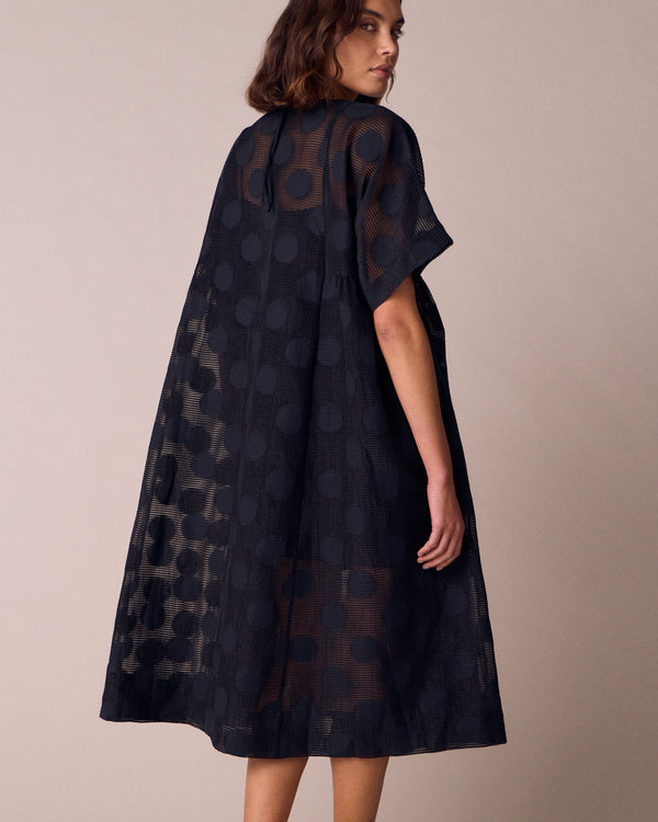 model wears zyla black sheer spot dress