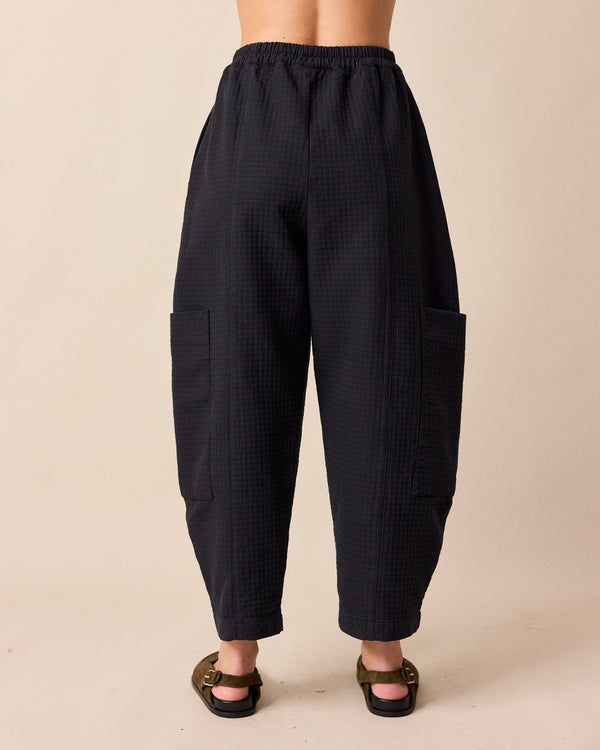 model wears amala black quilted cotton trousers back